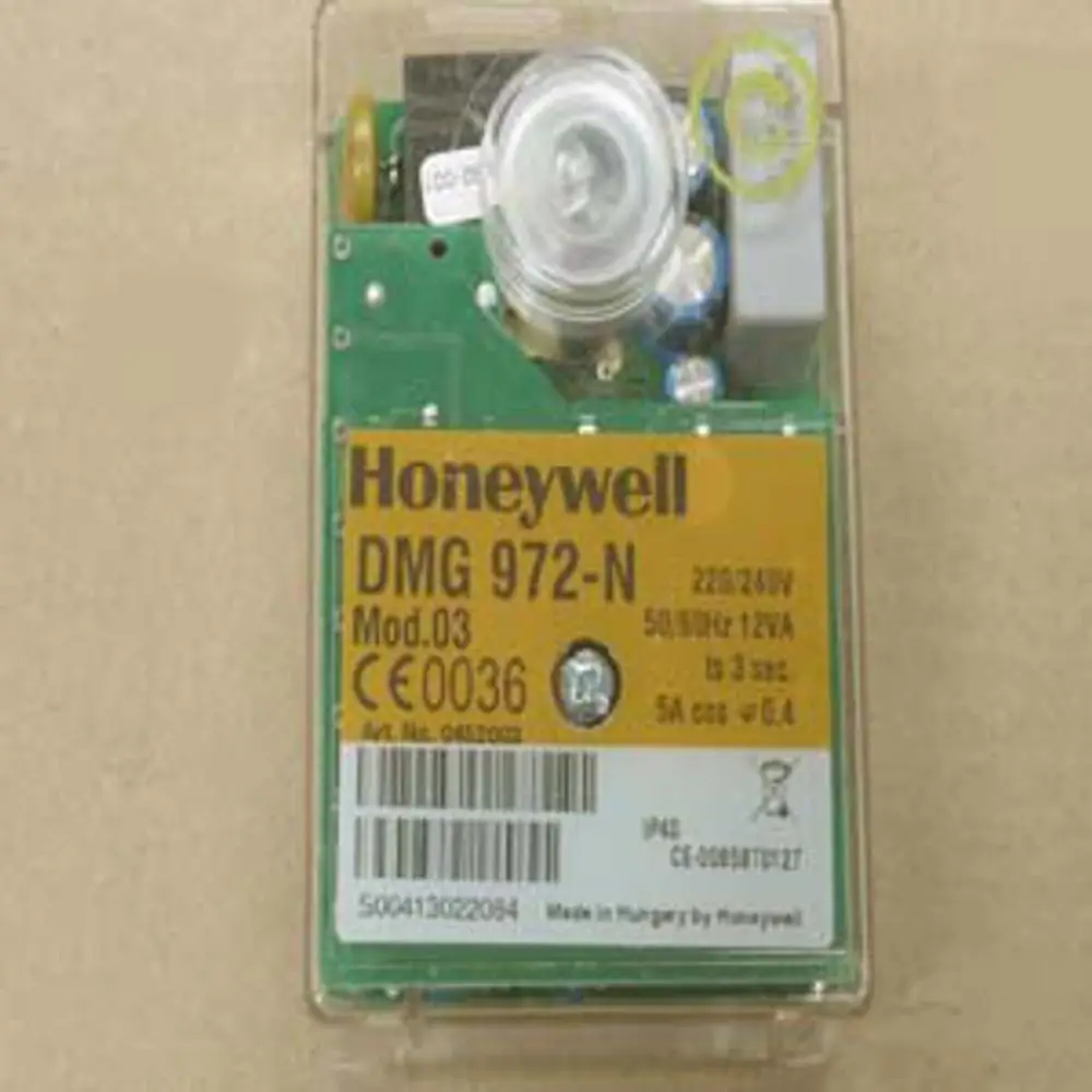 Steuergerät in transparenter Housing mit grüner Platine und gelber Beschriftung, hergestellt von Honeywell. Gerät hat mehrere Anschlussmöglichkeiten.